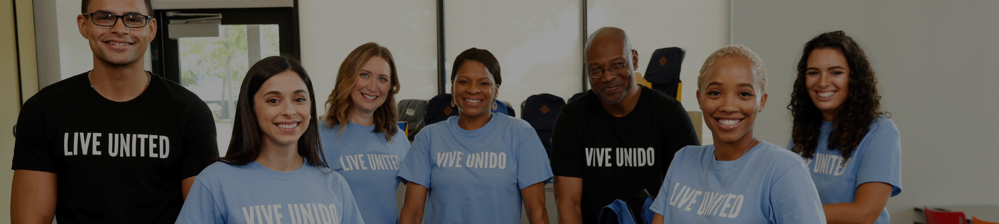 coworkers gathered in live united shirts